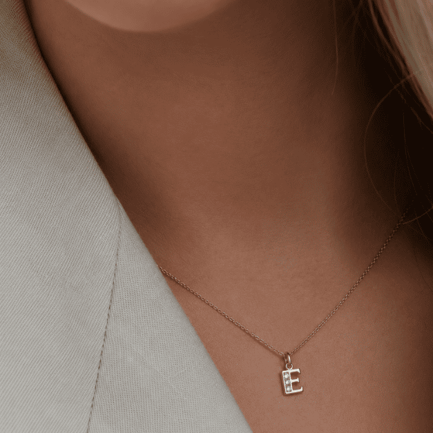 Buchstabenanhänger E 8K Gold Zirkonia am Model